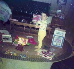 Me at 3 years old in yellow pajamas, surrounded by presents on Christmas morning 1975