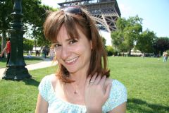 Nancy on the lawn near the Eiffel Tower, showing her engagement ring